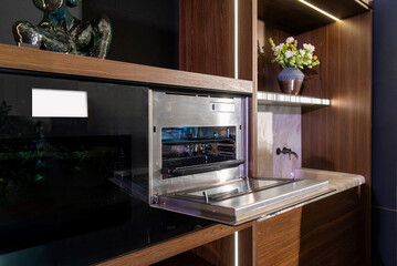 Wide view of stainless wall oven in luxury walnut kitchen