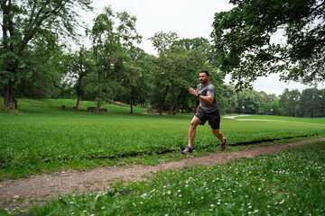 Man running spring at high speed in the park trail man in forties in amazing shape