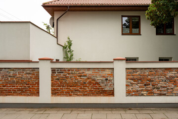 A residential house is well protected behind a solid brick fence. This substantial barrier ensures...