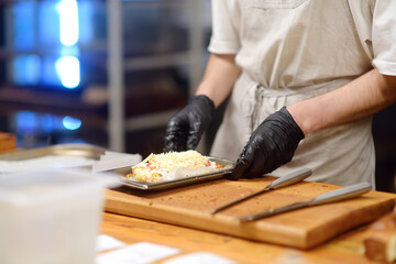 Close-up view of a restaurant or cafe kitchen and workers preparing food for customers.
