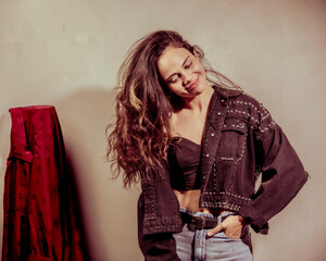 A playful and confident woman flaunts her style in an urban-inspired outfit, conveying a sense of...