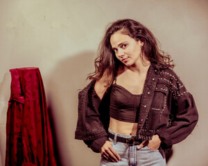 A stylishly dressed woman presents her artistic flair and confidence through a dynamic pose,...