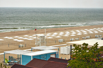 Top view of a Baltic Sea beach with white umbrellas on a cloudy day