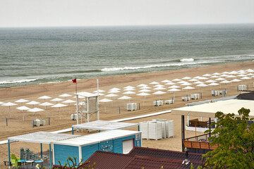 Top view of a Baltic Sea beach with white umbrellas on a cloudy day