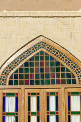 Stained glass door in Yazd, Iran, featuring vibrant geometric patterns and traditional Persian craftsmanship, reflecting the city's rich cultural heritage