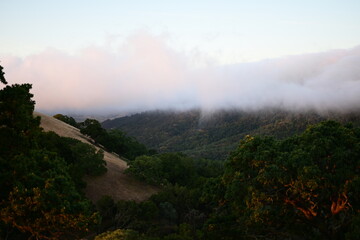 Blanket of fog rolling over a mountain ridge at sunrise