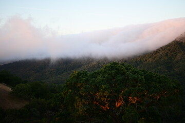 Blanket of fog rolling over a mountain ridge at sunrise
