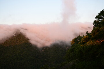 Blanket of fog rolling over a mountain ridge at sunrise