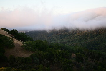Blanket of fog rolling over a mountain ridge at sunrise