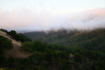 Blanket of fog rolling over a mountain ridge at sunrise