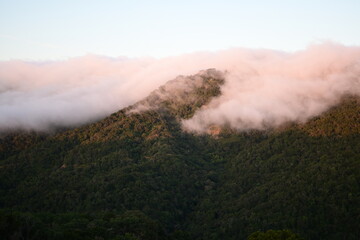 Blanket of fog rolling over a mountain ridge at sunrise