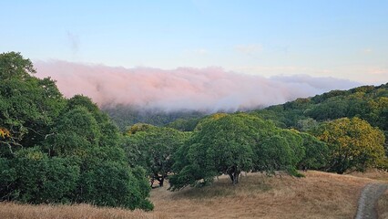 Blanket of fog rolling over a mountain ridge at sunrise