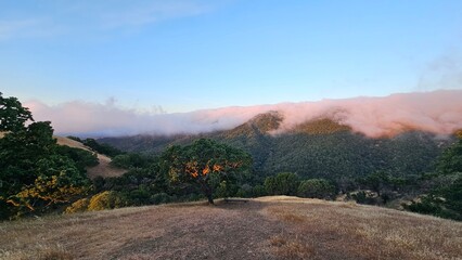 Blanket of fog rolling over a mountain ridge at sunrise