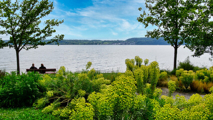 Ein Rentnerpaar genie&szlig;t auf einer Parkbank am &Uuml;berlinger Seeufer die herrlicheAussicht auf den Bodensee