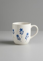 Floral Mug on Table - White Ceramic Coffee Cup with Blue Flower Design