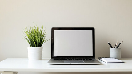 Fototapeta premium Clean white workspace with laptop, potted grass and stationery