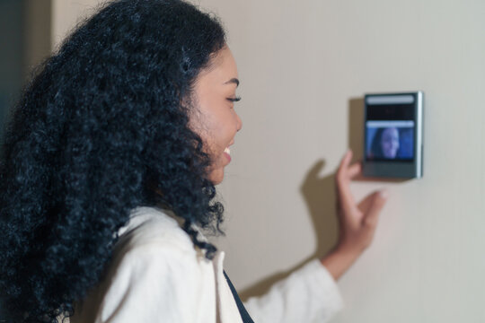 portrait headshot young female african company employee with curly hair standing at time attendance scanner,scanning fingerprint to enter security system
