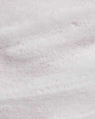 Soft cleansing foam and bubbles on pink background. Ideal for skincare, spa, cosmetic product backgrounds, or wellness-themed visuals.