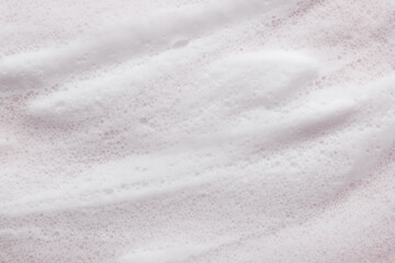 Soft cleansing foam and bubbles on pink background. Ideal for skincare, spa, cosmetic product backgrounds, or wellness-themed visuals.