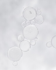 Transparent skincare serum texture with air bubbles on light background