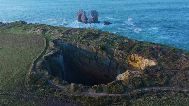 Aerial drone view of the Sima de Liencres and the Urro del Manzano in the Dunes of Liencres Natural Park. Pi&eacute;lagos Municipality, Costa Quebrada Geopark, Cantabrian Sea, Cantabria, Spain, Europe