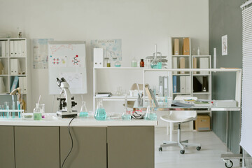Modern laboratory setting featuring various scientific equipment, glassware, and chemicals on...
