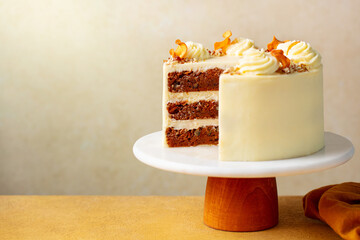 Carrot cake with cream cheese and pecan nuts. Beige background. Close up. Copy space.