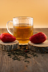 inviting close-up features a glass of green tea alongside vibrant strawberries, evoking a sense of refreshing comfort and natural sweetness. Ideal for healthy living, beverage, or food blog content