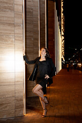A girl in a night city, a beautiful young girl walks through the night city in an evening dress and heels