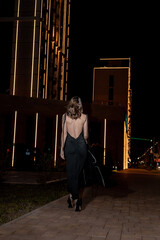 A girl in a night city, a beautiful young girl walks through the night city in an evening dress and heels