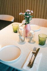 Elegant dining setup with floral centerpiece and green glassware in a cozy restaurant
