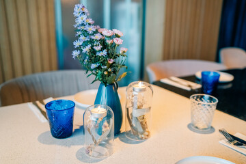 Elegant dining table setting with flowers and candles in a modern restaurant interior