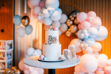 Colorful cake and decorations celebrate a gender reveal party with balloons and themed accents
