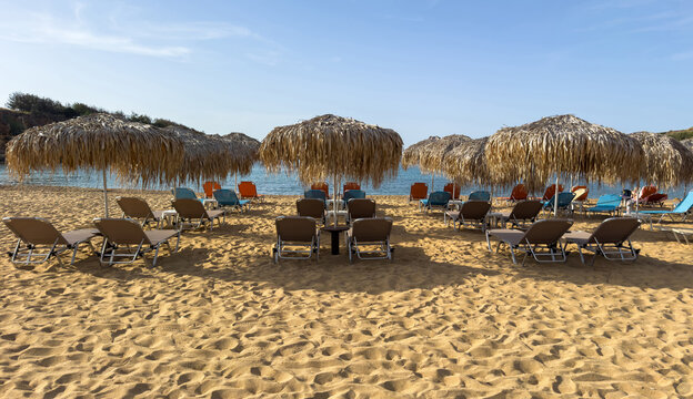 Straw umbrellas and beach chairs on sand, Sunny day at sea. Summer holidays