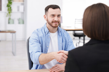 Fototapeta premium Recruiter and candidate shaking hands at desk in office