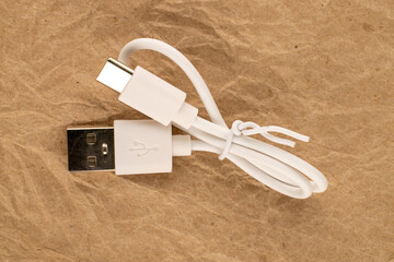 One USB cable on kraft paper, close-up, top view.