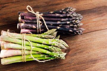 Fresh asparagus bundles displayed on a wooden surface ready for cooking or serving