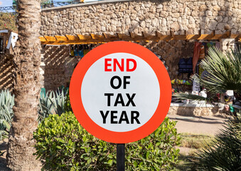 End of tax year symbol. Concept words phrase End of tax year on beautiful road sign. Beautiful palm...