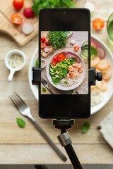 Smartphone on tripod, taking photo  of lunch bowl or salad.