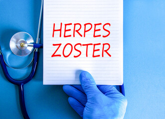 Herpes zoster symbol. Concept words Herpes zoster on beautiful white note. Doctor's hand in blue...