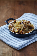 Onion with mushrooms. Rustic wooden background.