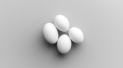 Four white eggs arranged on a light gray surface.