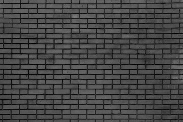 Black wall of black bricks - gloomy room. Industrial building background.