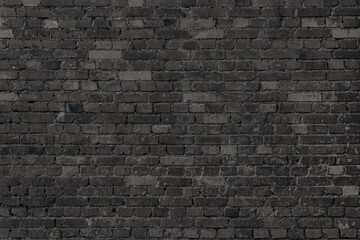 Black wall of black bricks - gloomy room. Industrial building background.