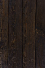 Fototapeta premium Dark brown wooden planks form a wall. Gloomy atmosphere. Natural wooden background.