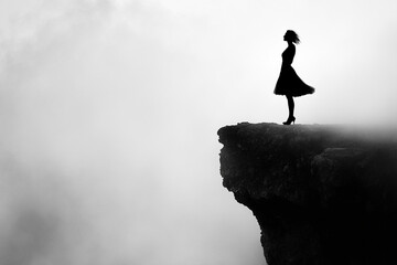 Silhouette of a woman standing on a cliffside