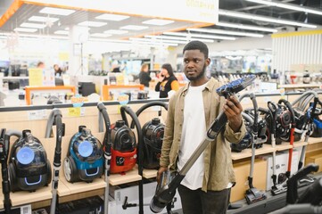 New vacuum cleaner. An African man buys a vacuum cleaner in a household goods store
