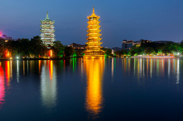 Night view of the Sun and Moon Twin Pagodas at Shanhu Lake (Fir Lake). Gold and Silver Pagodas illuminated at downtown of Guilin, China. Guilin is a popular tourist destination of Asia.