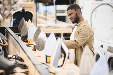 Man choosing electric iron at store