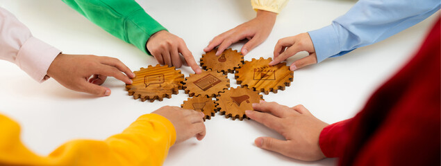 This image showcases diverse hands engaging with wooden gear symbols, representing the essence of...